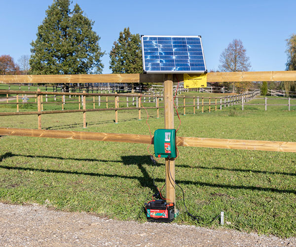 Weidezaungerät installiert an einem elektrifizierten Weidezaun mit Solarpaneel