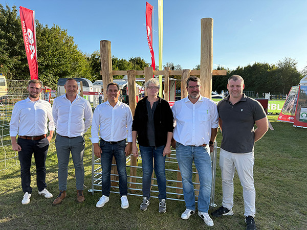 Mehrere Mitarbeiter von Kerbl und AKO auf dem auf dem Außengelände der Messe MeLa 2025 vor dem Messestand von AKO und Kerbl